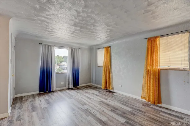 an empty room with windows and closet