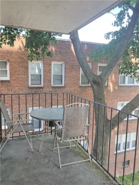87 Glenbrook Road, Unit 3E Stamford, CT 06902 - Photo 2 of 11 a patio with table and chairs and potted plants