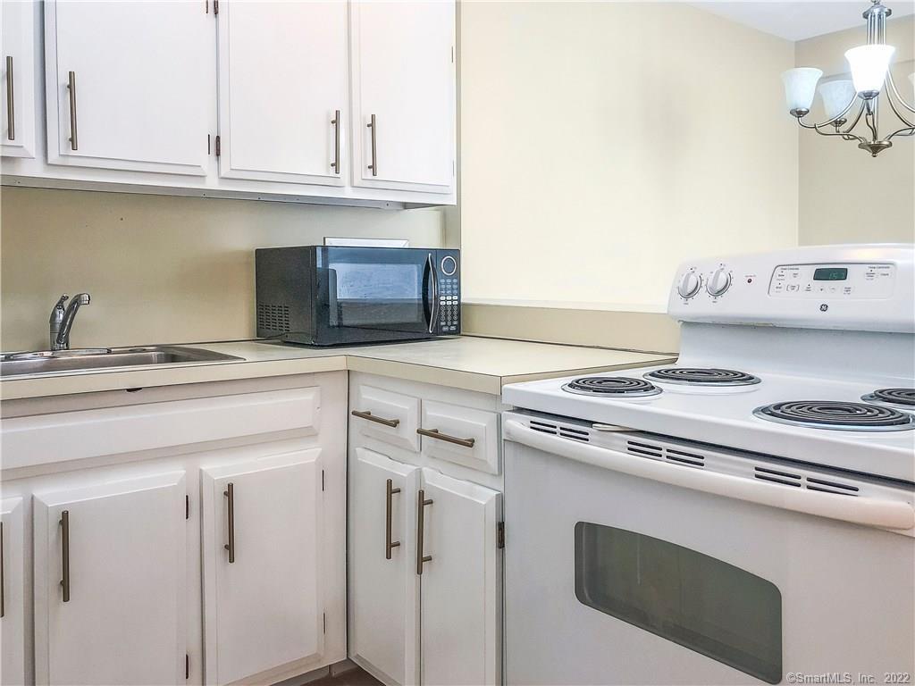 87 Glenbrook Road, Unit 3E Stamford, CT 06902 - Photo 7 of 11 a kitchen with granite countertop white cabinets and white appliances