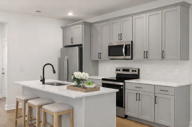 a kitchen with stainless steel appliances granite countertop a stove a sink and a microwave