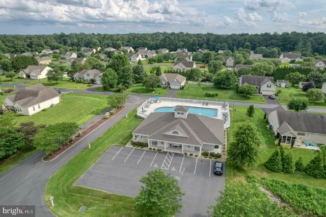 a kitchen with stainless steel appliances kitchen island granite countertop a table chairs and a refrigerator