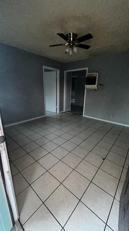 508 Bremser Avenue, Unit 506 Killeen, TX 76541 - Photo 5 of 9 Spare room with light tile patterned floors, a textured ceiling, and a ceiling fan