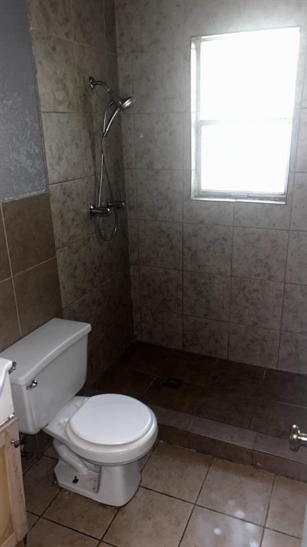 508 Bremser Avenue, Unit 506 Killeen, TX 76541 - Photo 8 of 9 Full bath featuring a shower stall, vanity, tile walls, and tile patterned flooring