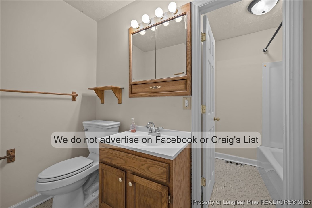 5842 Columbine Road Fayetteville, NC 28306 - Photo 4 of 13 a bathroom with a sink and a toilet