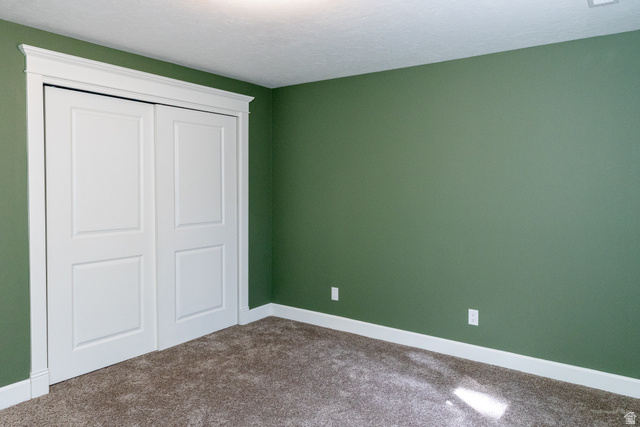 434 Cardon Ridge Drive Smithfield, UT 84335 - Photo 40 of 59 Unfurnished bedroom featuring carpet floors, a closet, and a textured ceiling