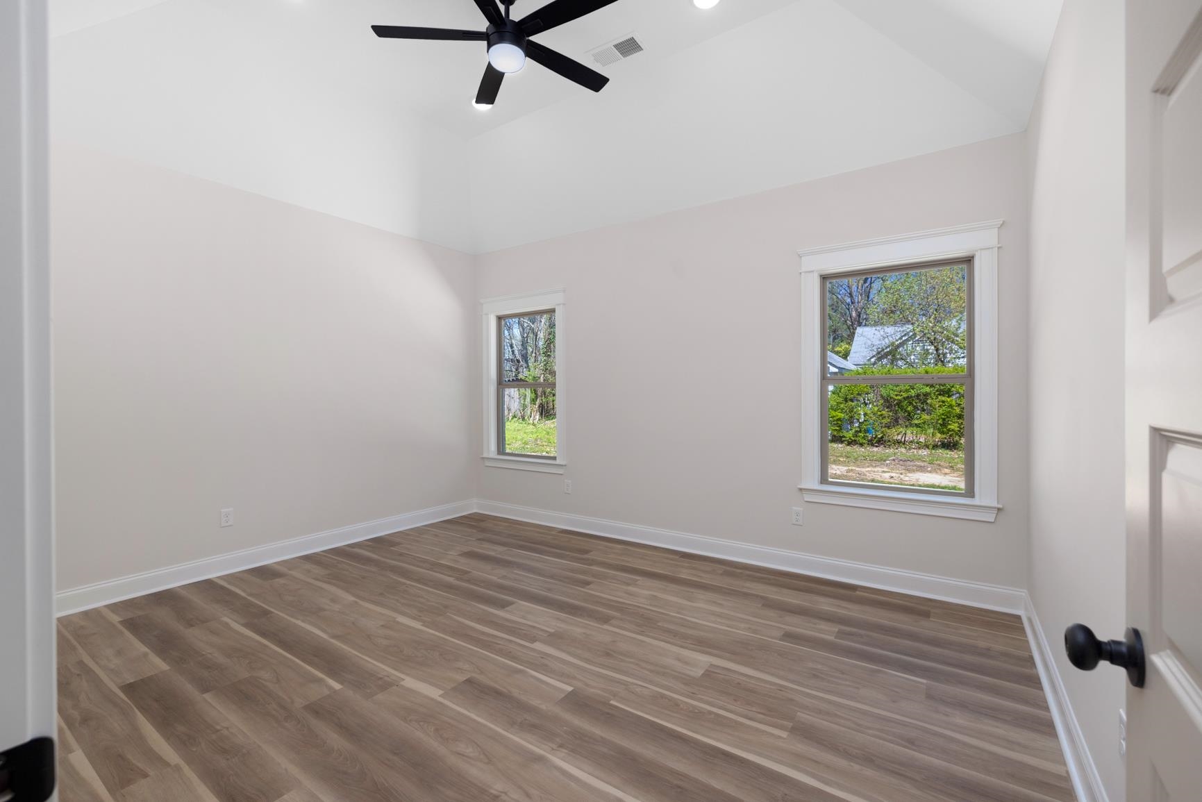 319 North Maple Street Covington, TN 38019 - Photo 18 of 32 Spare room featuring a ceiling fan, dark wood-style floors, lofted ceiling, healthy amount of natural light, and recessed lighting