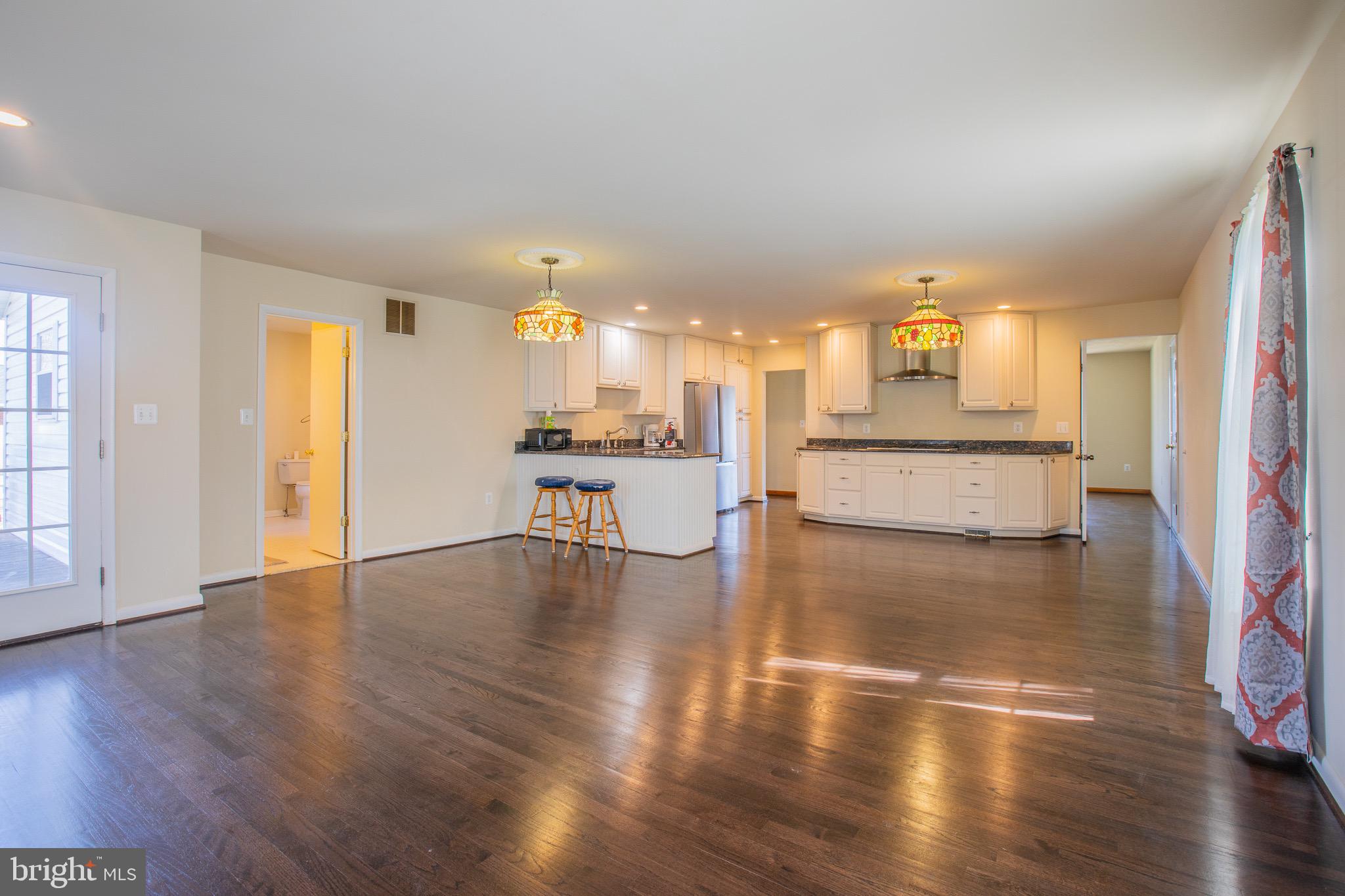 5806 Olson Road Brooklyn, MD 21225 - Photo 13 of 33 a view of a kitchen with kitchen island a sink wooden floor and a view of living room