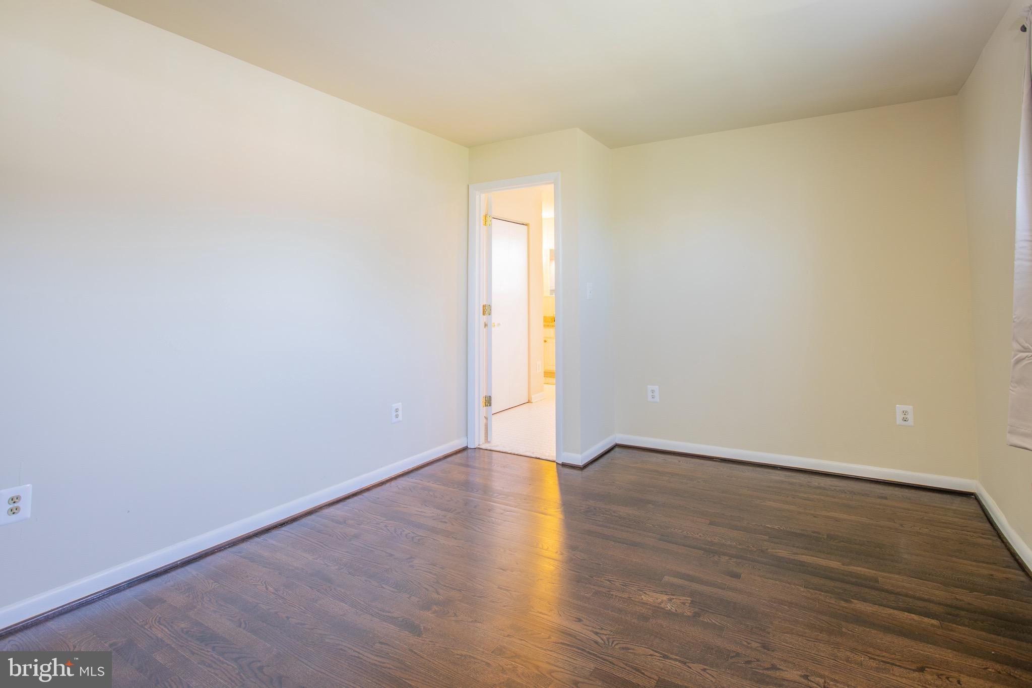 5806 Olson Road Brooklyn, MD 21225 - Photo 17 of 33 a view of an empty room with wooden floor and a window