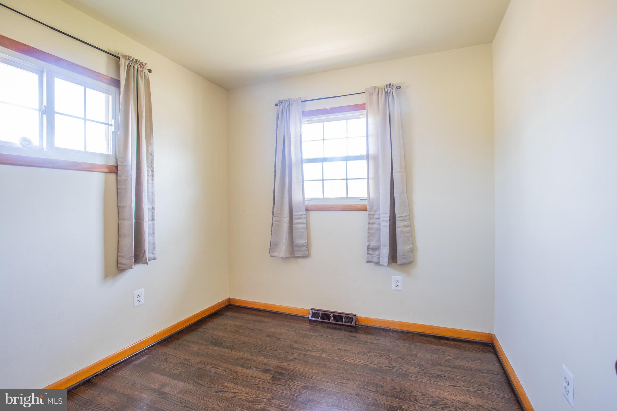5806 Olson Road Brooklyn, MD 21225 - Photo 18 of 33 an empty room with wooden floor and windows