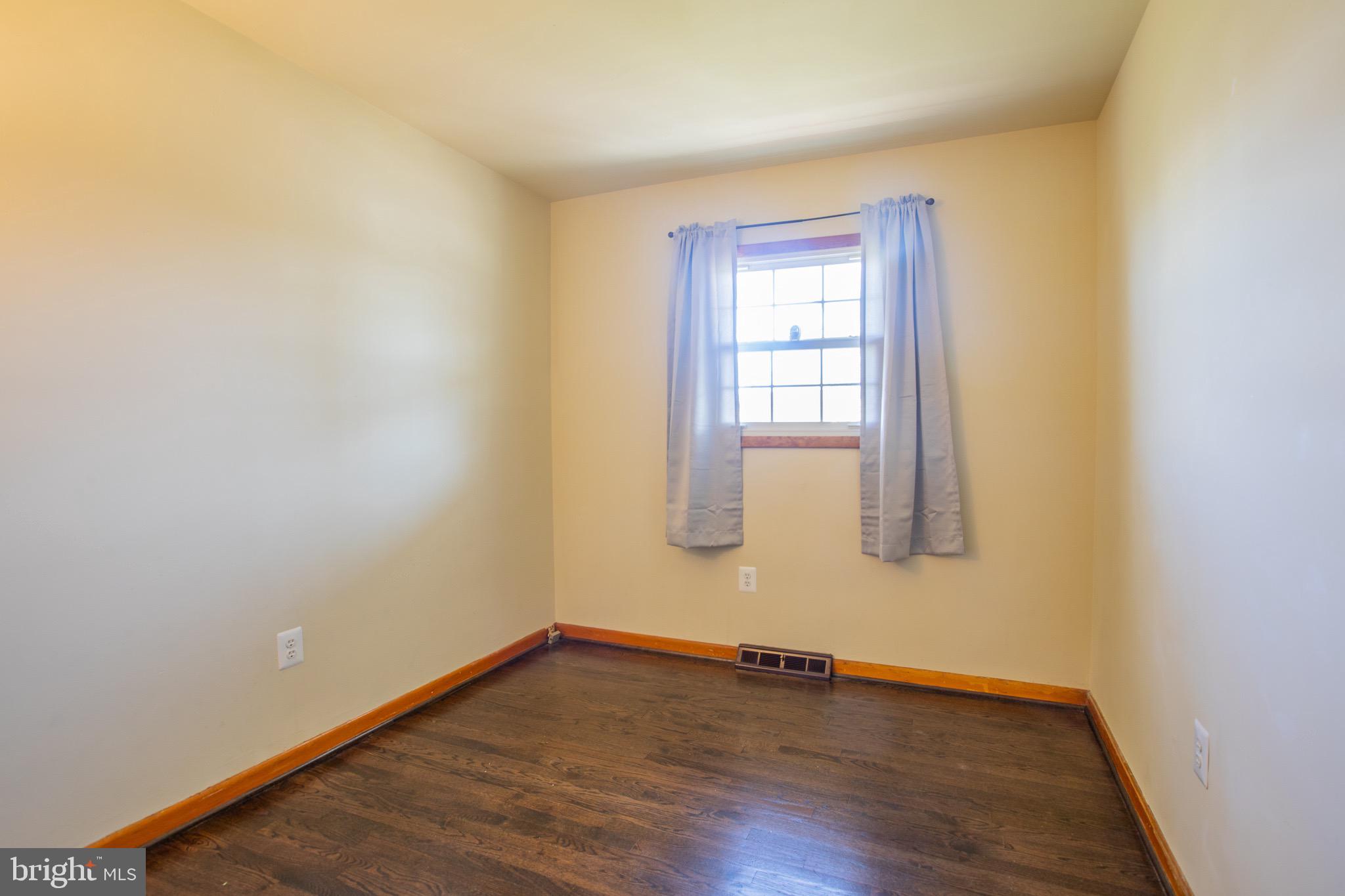 5806 Olson Road Brooklyn, MD 21225 - Photo 20 of 33 a view of an empty room with wooden floor and a window