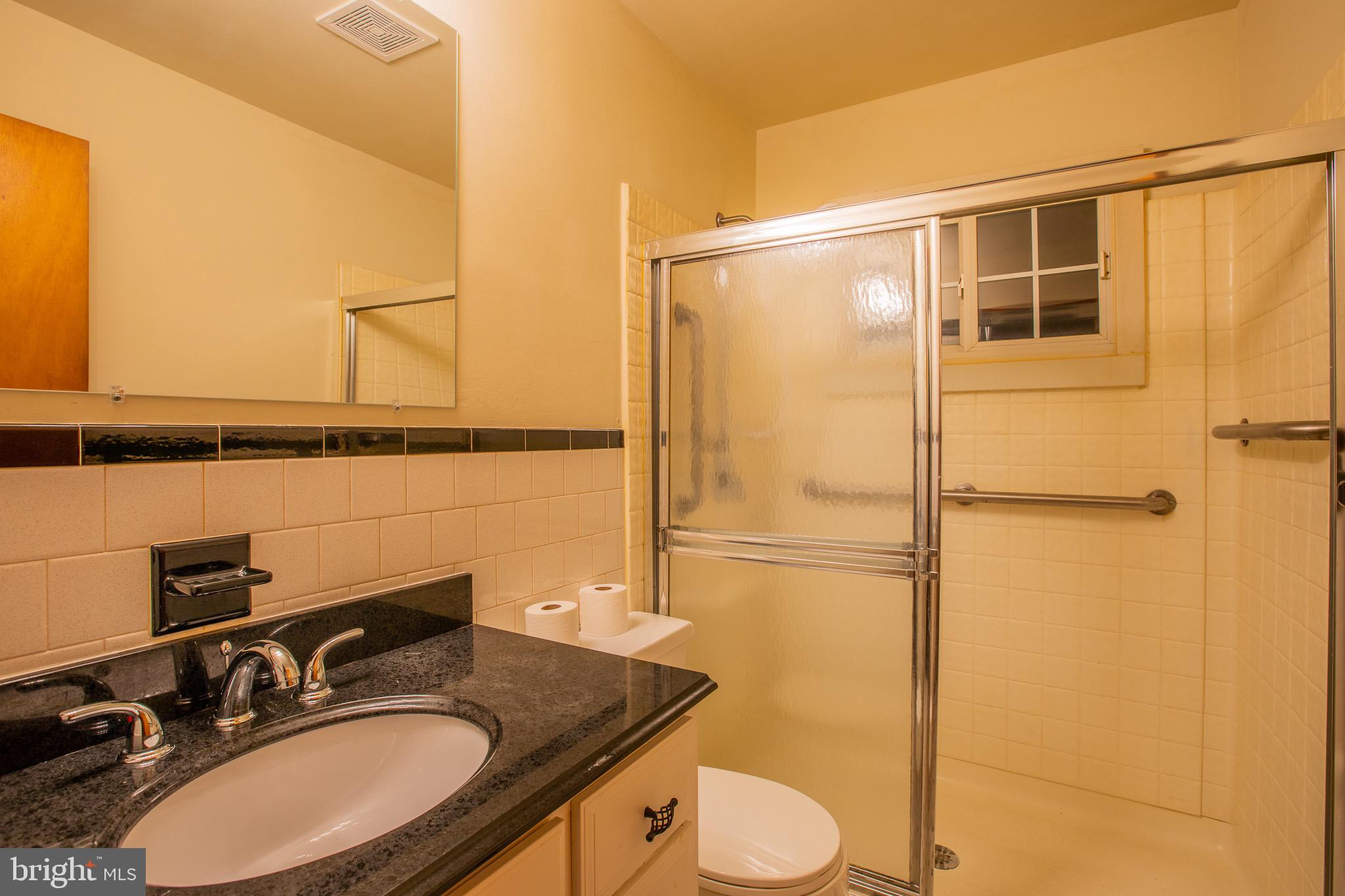 5806 Olson Road Brooklyn, MD 21225 - Photo 23 of 33 a bathroom with a granite countertop sink toilet and shower