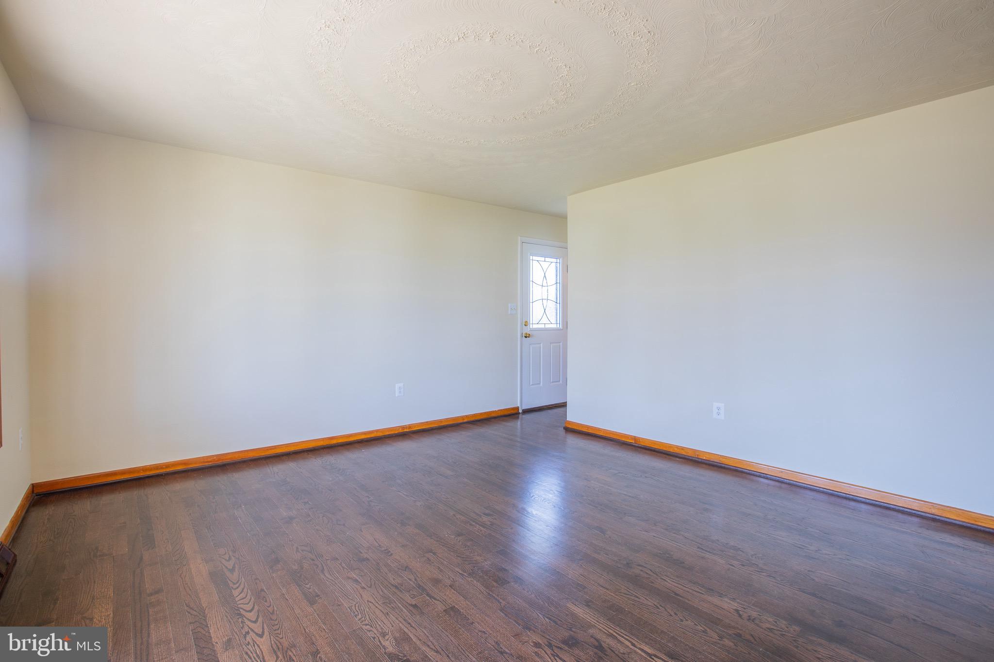 5806 Olson Road Brooklyn, MD 21225 - Photo 4 of 33 a view of an empty room with wooden floor