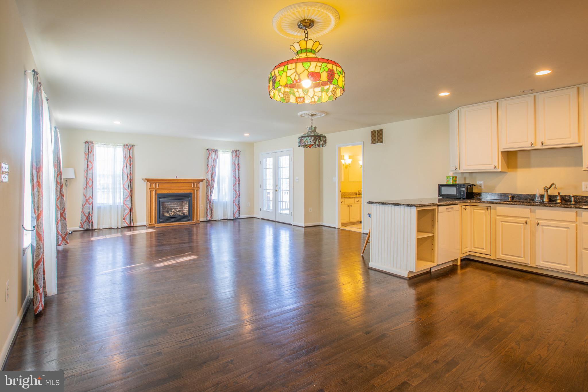5806 Olson Road Brooklyn, MD 21225 - Photo 7 of 33 an open kitchen with furniture and a wooden floor