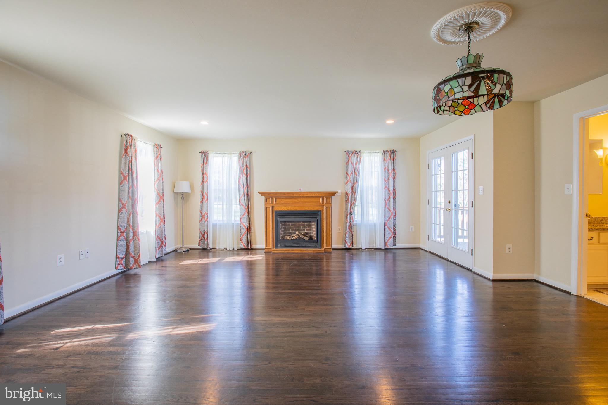 5806 Olson Road Brooklyn, MD 21225 - Photo 8 of 33 a view of an empty room with wooden floor and a window