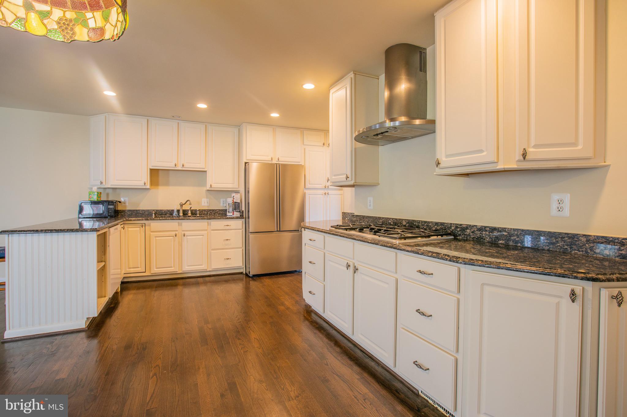 5806 Olson Road Brooklyn, MD 21225 - Photo 9 of 33 a kitchen with granite countertop white cabinets and stainless steel appliances