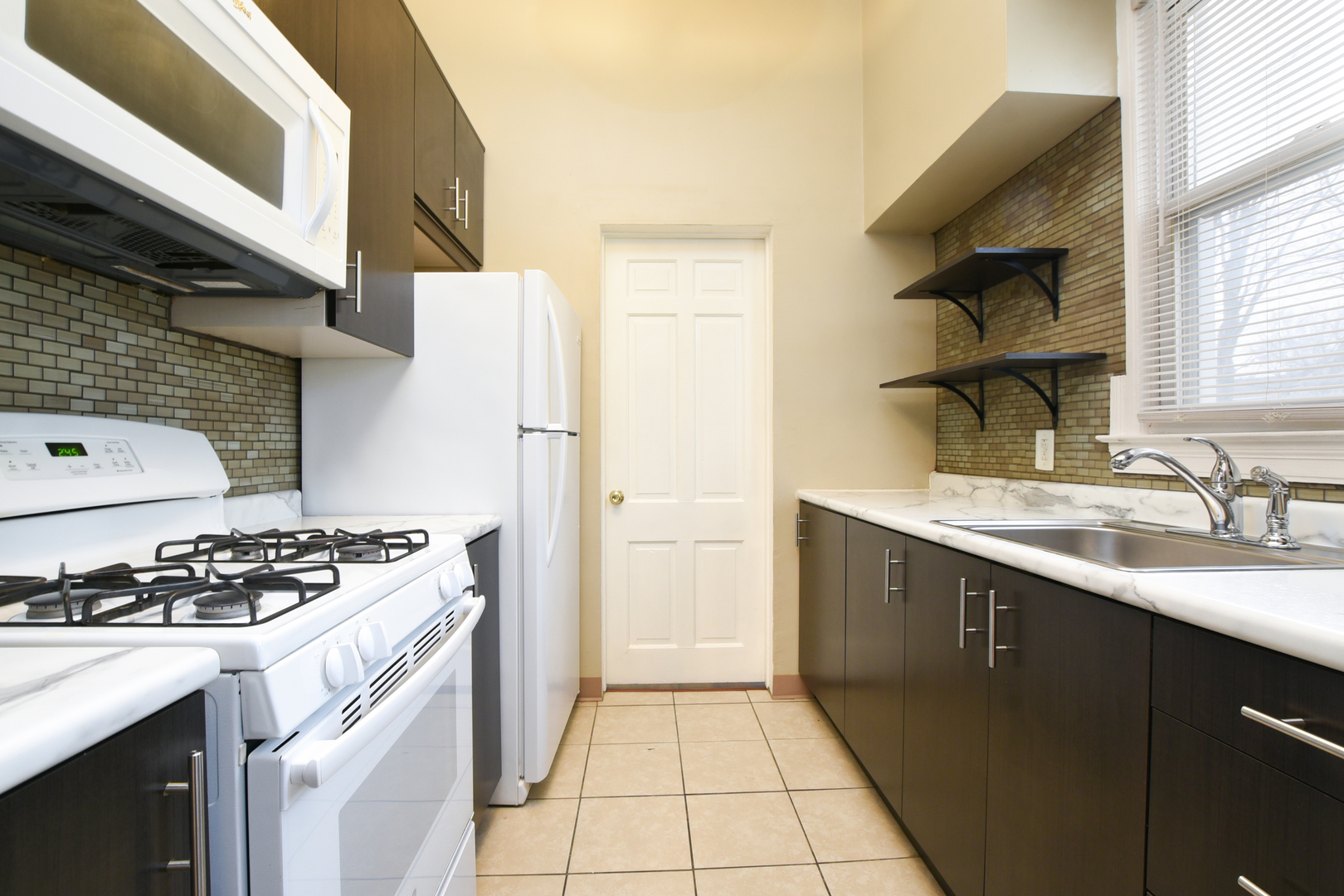 255 North Spring Street Elgin, IL 60120 - Photo 3 of 6 a kitchen with a sink a stove and refrigerator