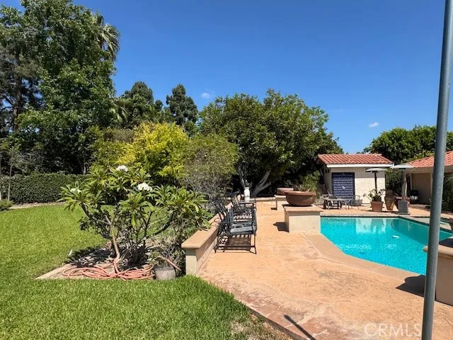 a view of a house with pool fire pit a yard a patio and swimming pool