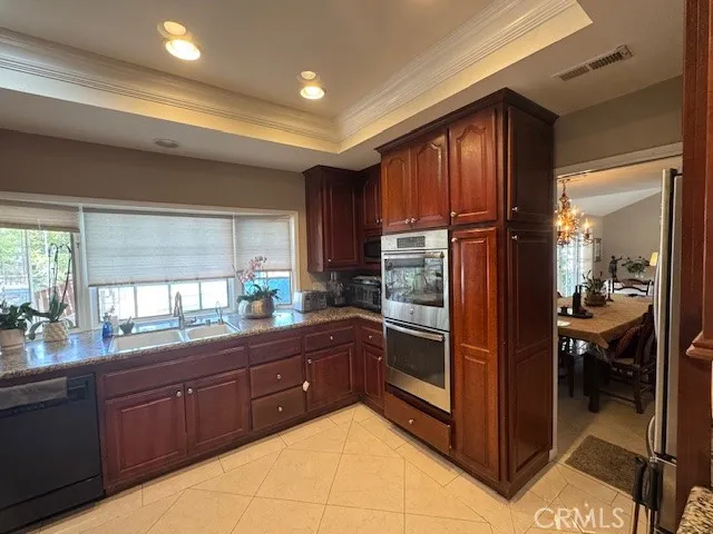 a kitchen with stainless steel appliances granite countertop a refrigerator and wooden cabinets
