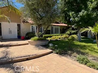 a view of a house with a yard and potted plants