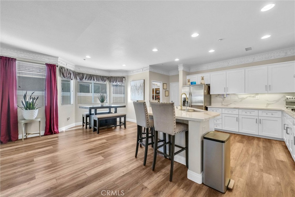 11499 Bridgeway Drive Riverside, CA 92505 - Photo 13 of 70 a kitchen with stainless steel appliances granite countertop a stove a refrigerator a kitchen island a dining table and chairs with wooden floor