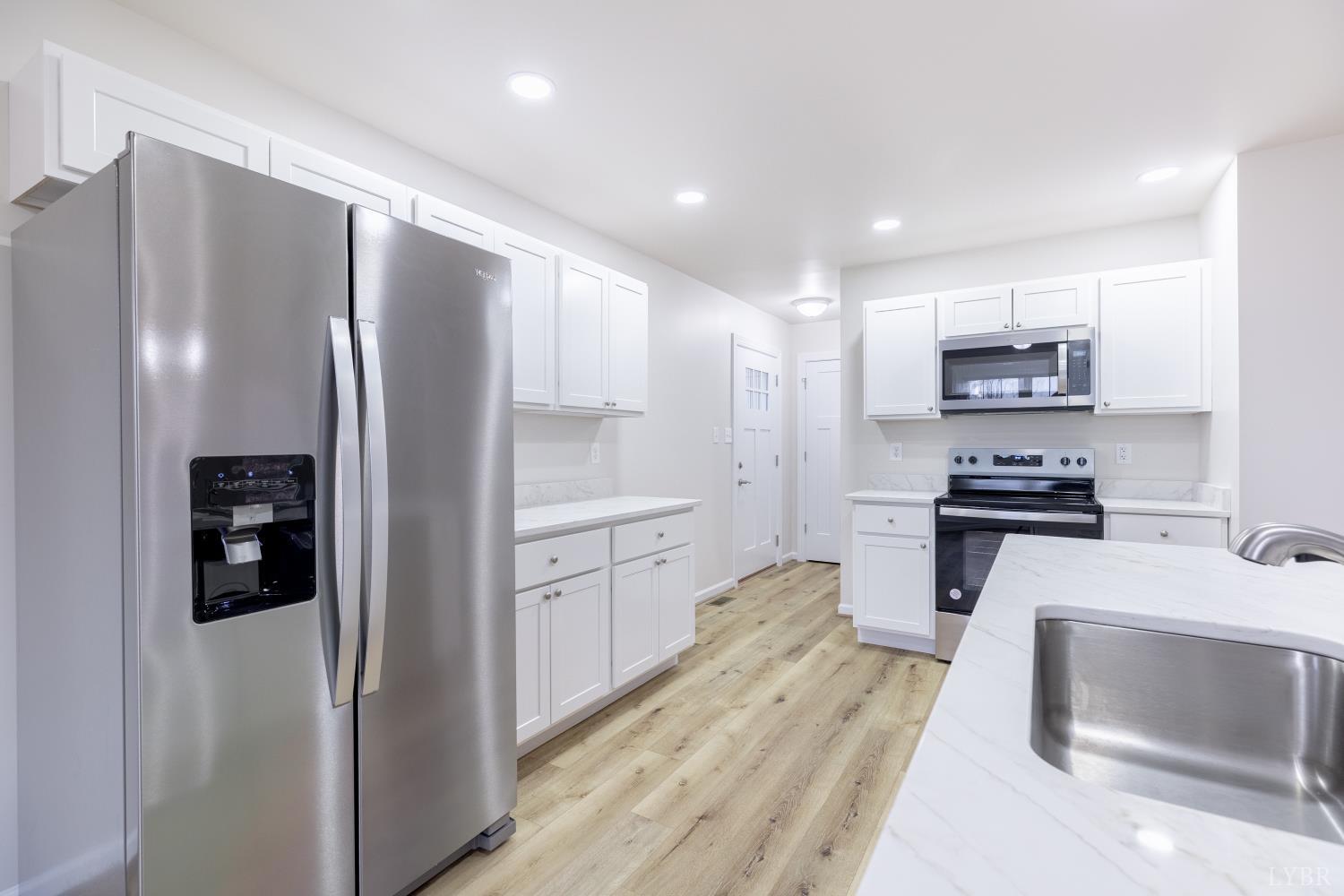1104 15th Street Altavista, VA 24517 - Photo 13 of 47 a kitchen with granite countertop a refrigerator and a stove top oven