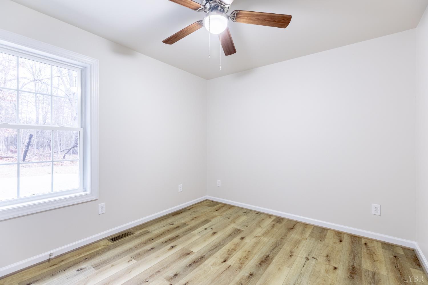 1104 15th Street Altavista, VA 24517 - Photo 22 of 47 an empty room with a window and a ceiling fan