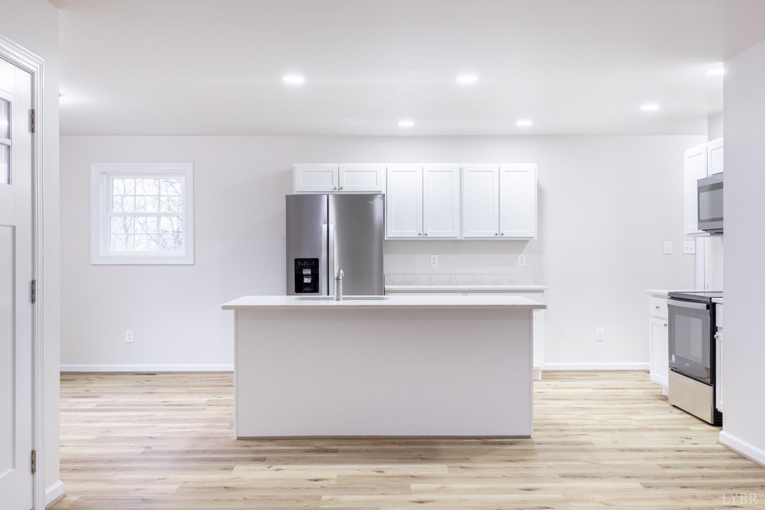 1104 15th Street Altavista, VA 24517 - Photo 9 of 47 a view with kitchen island a sink wooden floor and a refrigerator