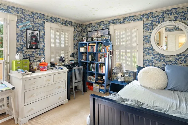 a bedroom with a bed a bookshelf and a window