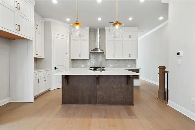 a large kitchen with stainless steel appliances kitchen island granite countertop a stove a sink a refrigerator and white cabinets