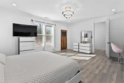 a spacious bedroom with a bed and a television