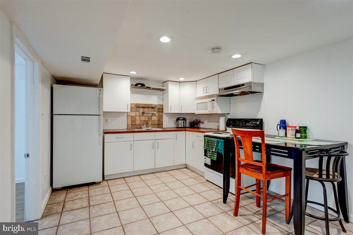 3312 Clay Street Silver Spring, MD 20902 - Photo 29 of 35 a kitchen with a dining table chairs refrigerator and cabinets