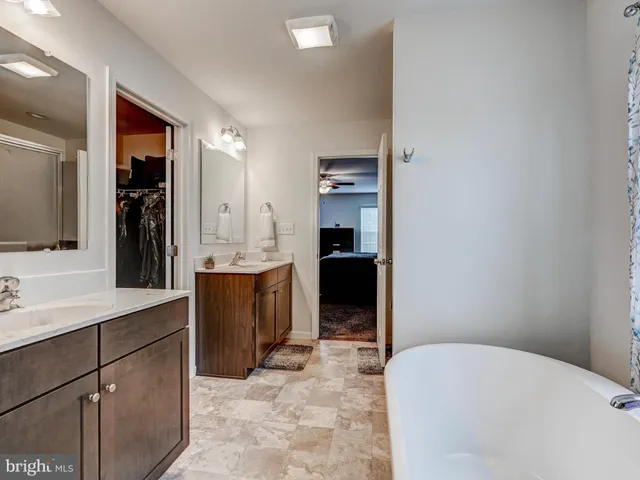 a bathroom with a bathtub sink and mirror