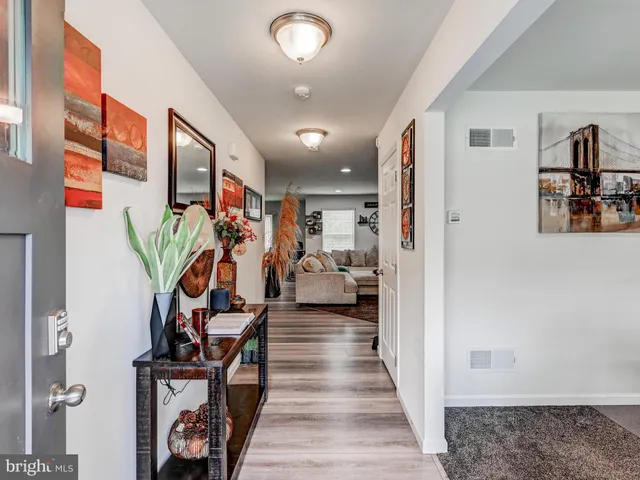 a view of a hallway with wooden floor and furniture