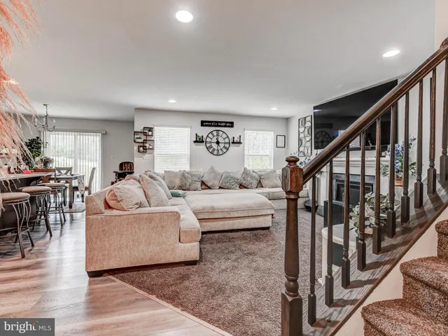 a living room with furniture and a dining table with wooden floor