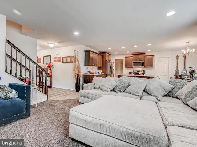 a living room with furniture and a kitchen view