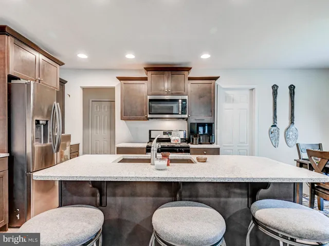 a kitchen with a table chairs stove and refrigerator