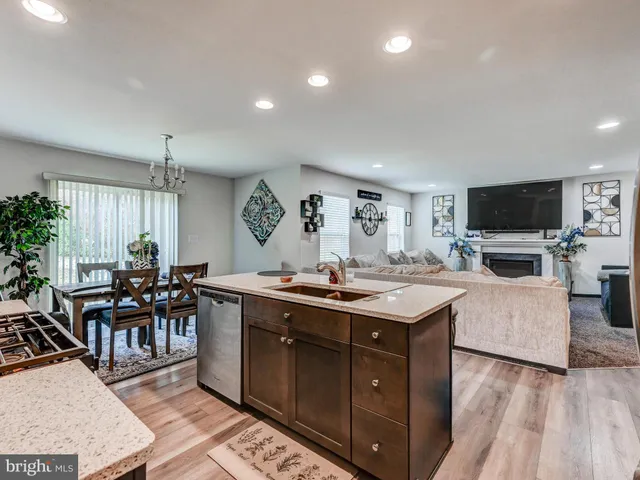 a living room with furniture a flat screen tv and kitchen view