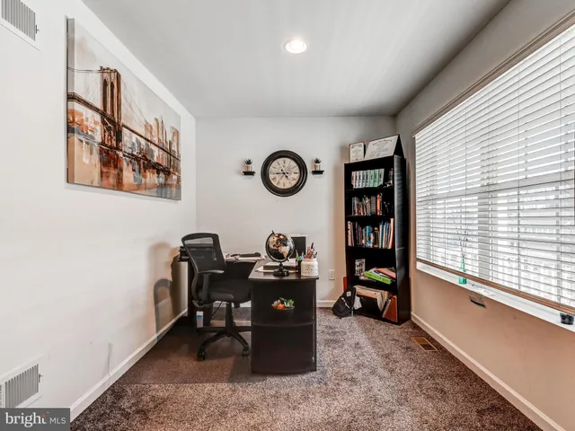 a view of a workspace with furniture and a window