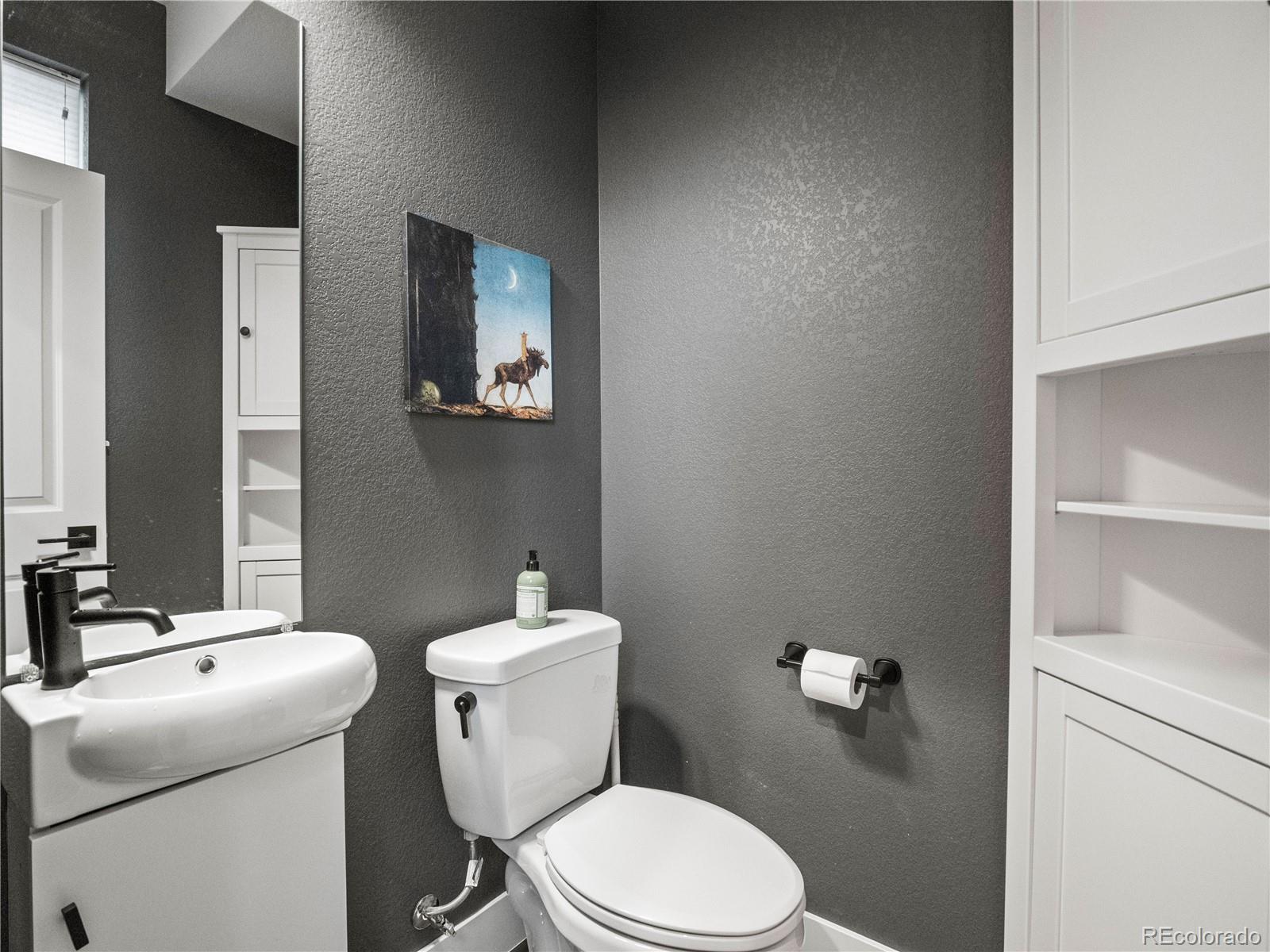 1284 Stuart Street Denver, CO 80204 - Photo 11 of 27 a white toilet sitting next to a bathroom sink