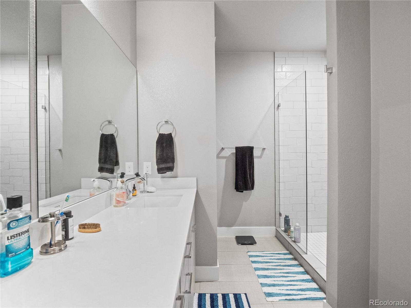 1284 Stuart Street Denver, CO 80204 - Photo 17 of 27 a bathroom with double vanity sink and two mirror
