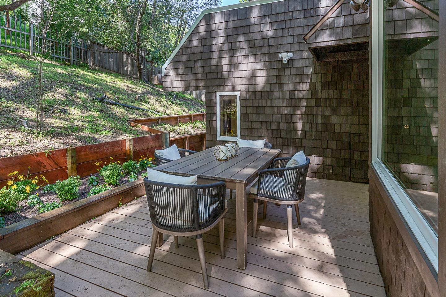 128 Los Trancos Circle Portola Valley, CA 94028 - Photo 23 of 38 a view of a patio with table and chairs with wooden floor and fence