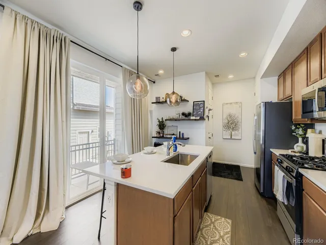 a kitchen with a sink a counter top space stainless steel appliances and a large window