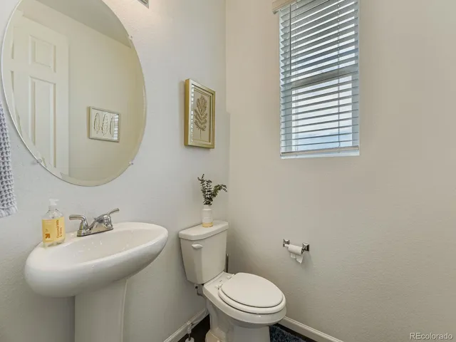 a bathroom with a sink a toilet and mirror
