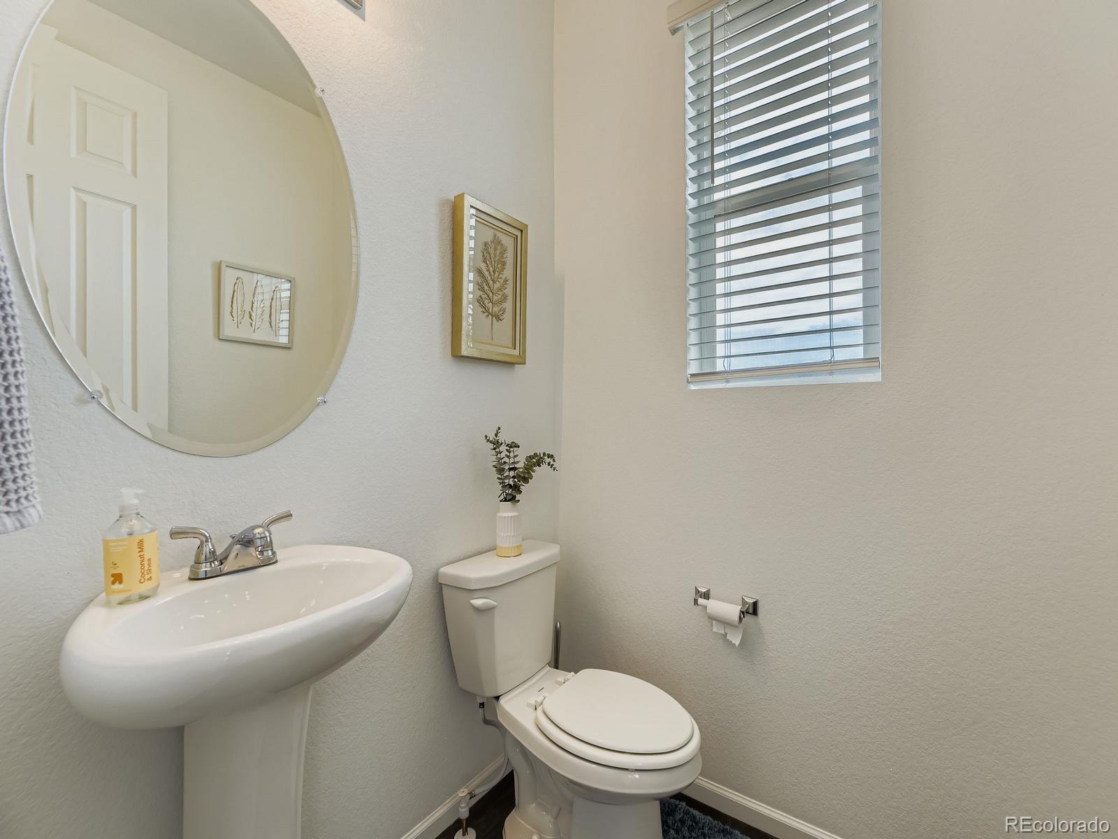 1680 South Tower Road Aurora, CO 80017 - Photo 16 of 26 a bathroom with a sink a toilet and mirror