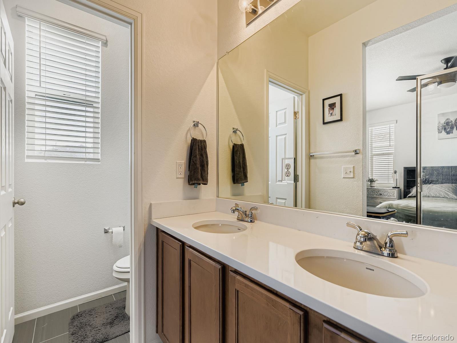 1680 South Tower Road Aurora, CO 80017 - Photo 19 of 26 a bathroom with a granite countertop sink and a mirror