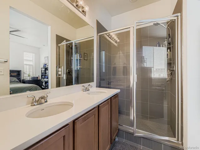 a bathroom with a sink shower and a mirror