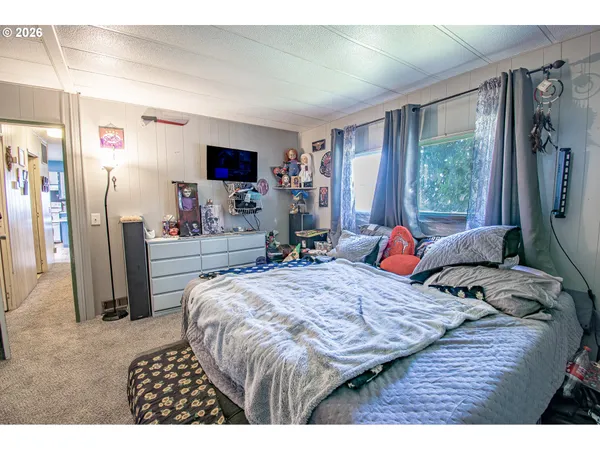 a bedroom with a bed and a flat screen tv