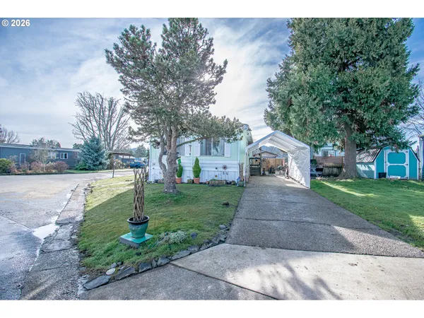 a front view of a house with a yard and trees