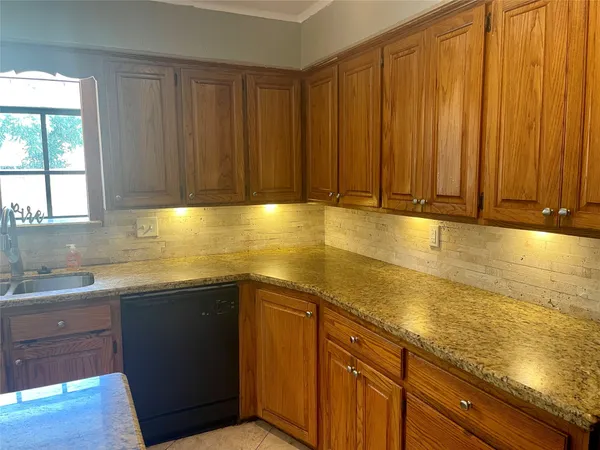 a kitchen with stainless steel appliances granite countertop wooden cabinets a sink and dishwasher