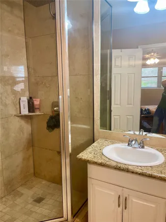a bathroom with a granite countertop sink and a mirror